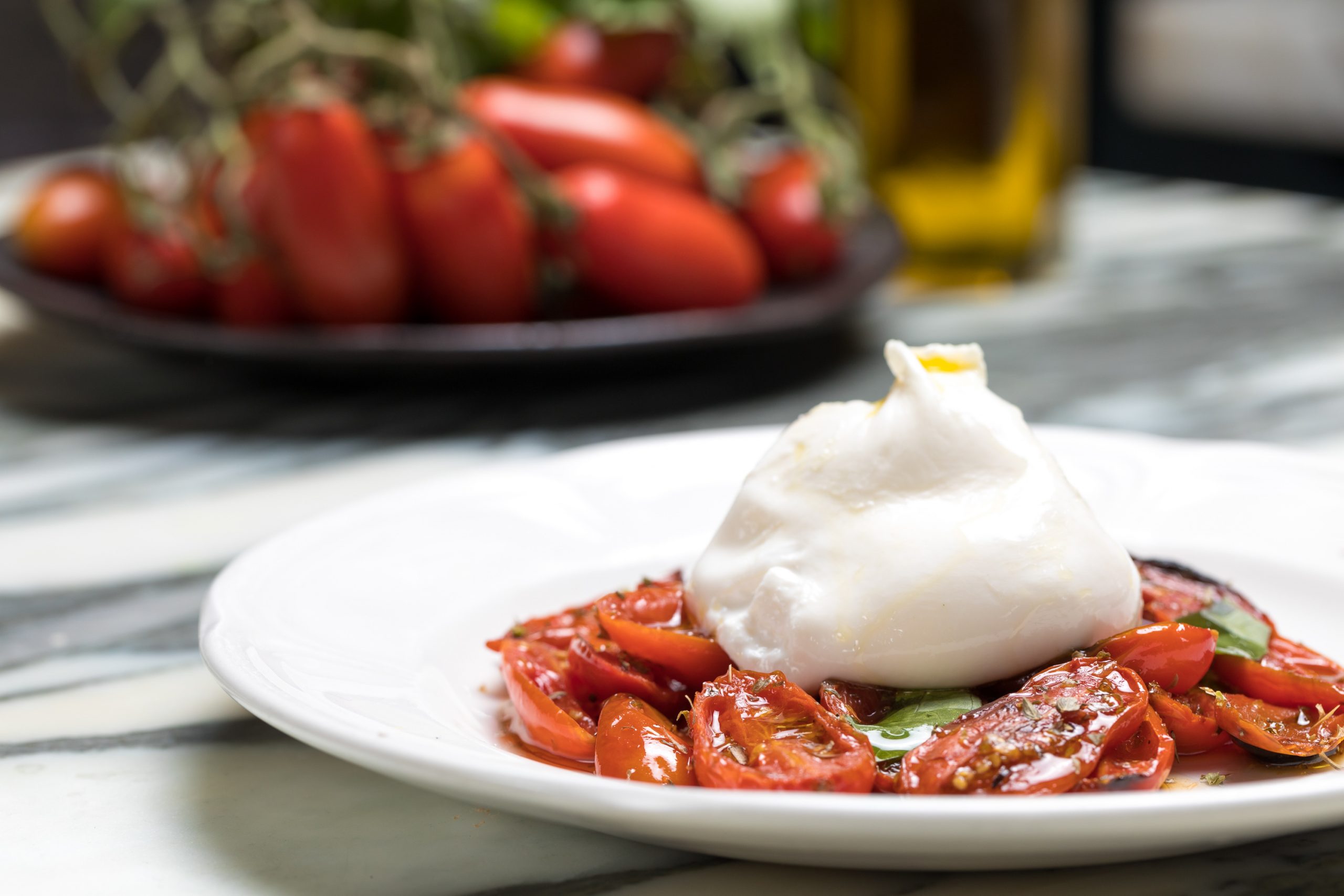 Mozzarella sitting on a bed of tomatoes - Healthy Italian Dishes